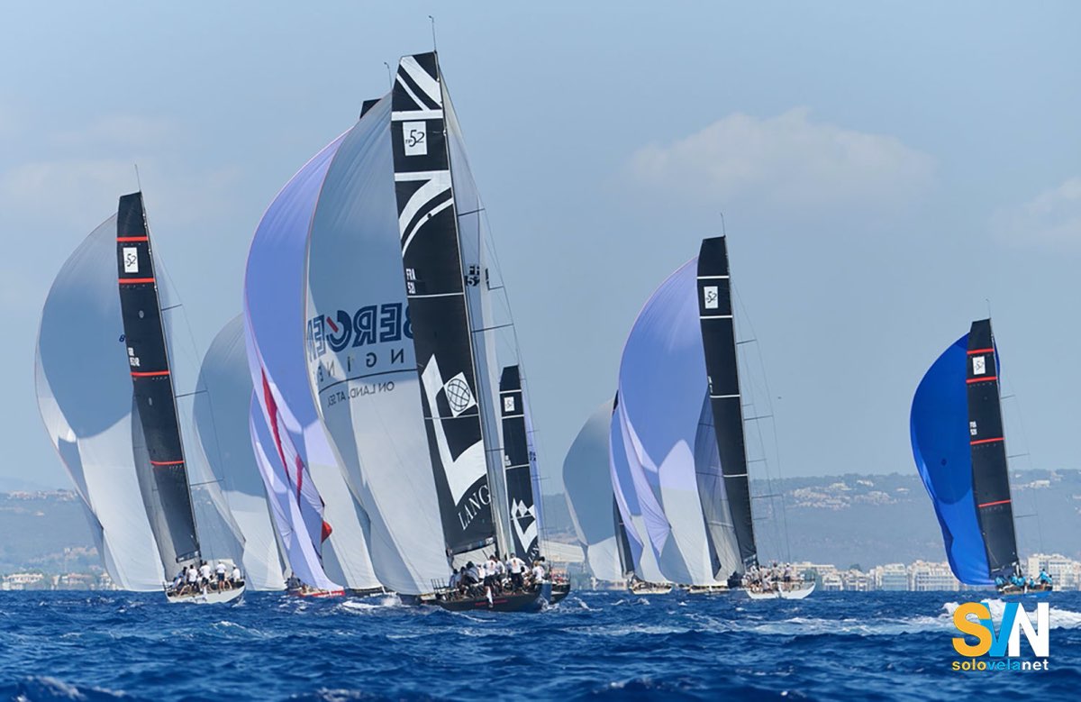 Regata con spinnaker issati: diverse barche al lasco mostrano chiaramente come la forma e la regolazione dello spi influenzino velocità e stabilità in navigazione