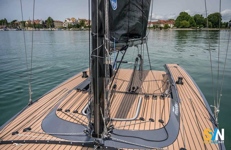 Il ponte del Lago 26 Speedster visto da prua: coperta in teak, albero in carbonio e manovre rinviate in pozzetto per una gestione semplificata anche in solitario
