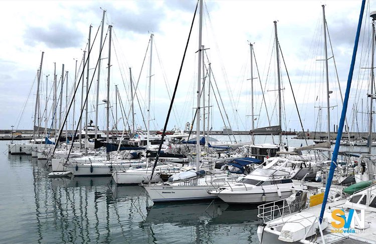 Un classico marina Mediterraneo dove le barche ormeggiano poppa alla banchina e davanti hanno la trappa