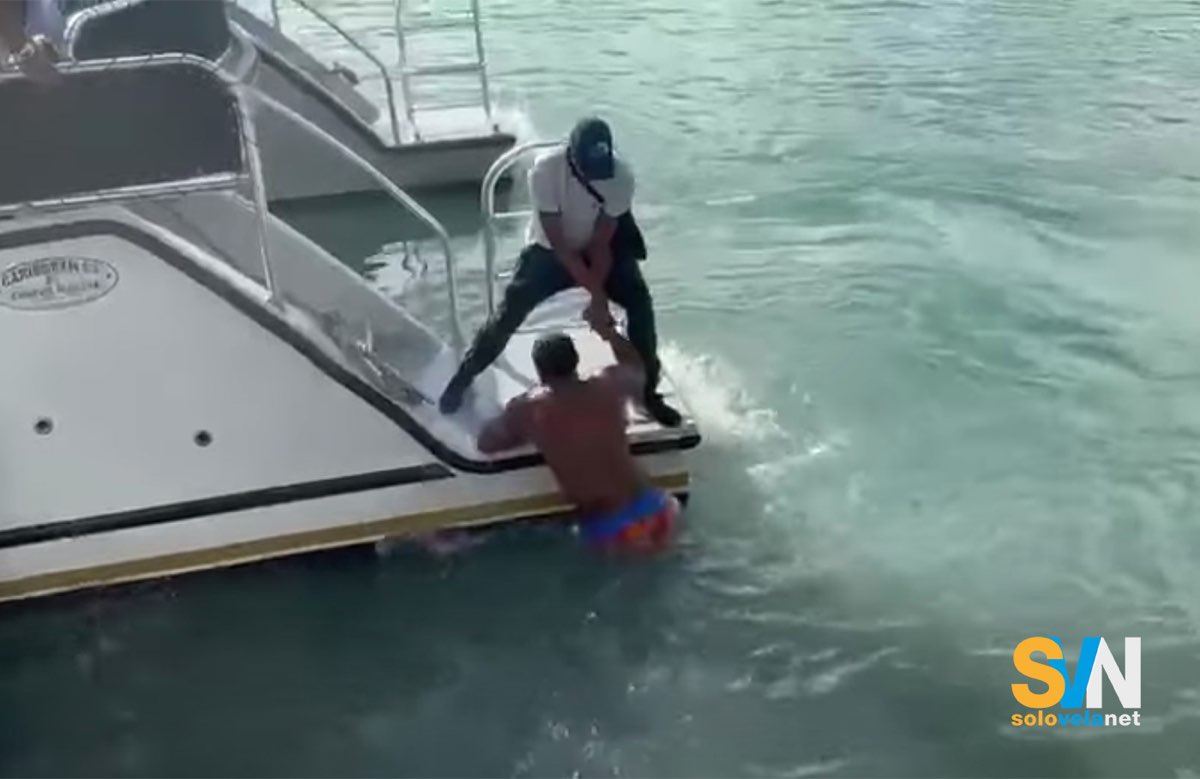 Un frame del video dell'uomo quando viene soccorso da un passeggero per salire a bordo del catamarano. Il passeggero non ha ancora capito che l'uomo in mare ha perso il piede tranciato dall'elica.