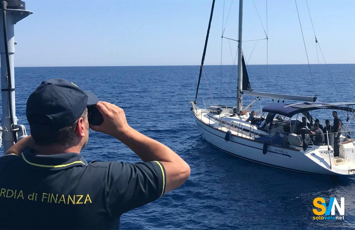 Una motovedetta della Guardia di Finanza ferma una barca a vela in mare