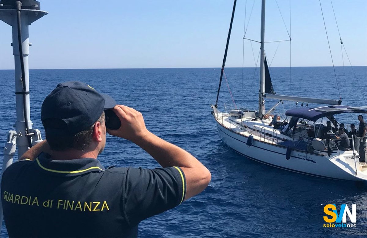 Una motovedetta della Guardia di Finanza ferma una barca a vela in mare